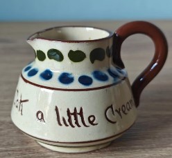A small creamer with a handleAI-generated content may be incorrect.